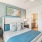 bedroom with teal accents and a large plant next to the window